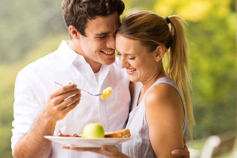 husband-feeding-wife-breakfast-loving-outdoors-50965754